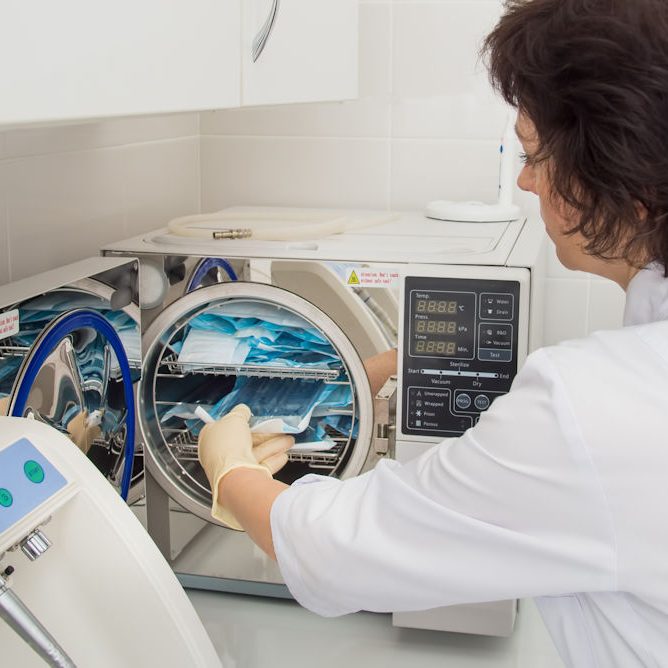 Instrument sterilization in dentistry, nurse loading instrumenst in sterilizer
